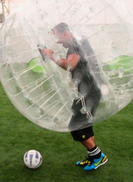 Man from a stag party playing Bubble Football with the ball at his feet