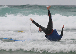man being flipped off a surfboard