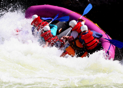 a pink raft tipping over whilst White water rafting 