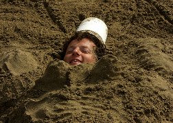 Man buried in the sand as a stag do prank