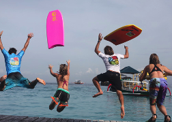 guys from a stag party jumping with Body Boards