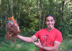 Man Holding Up Kindling on Fire