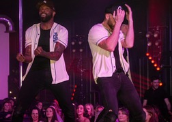 Dreamboys dancing in white shirts and black baseball caps