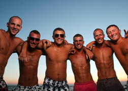 Lads having group hug on beach