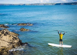 Person on Stand Up Paddle Board in sea in Newquay