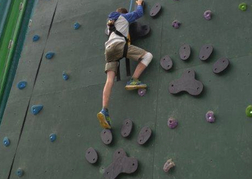 Man on a climbing wall on a stag do