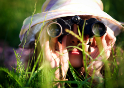 Lady in the grass on a hen weekend looking for treasure