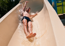 Man going down a water slide on his stag do