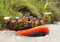 White water rafting stag group put their paddles in the air