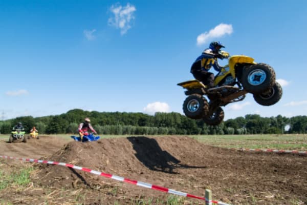 stag party racing Quad bikes in Bournemouth, one of the bikes going over a jump and getting air