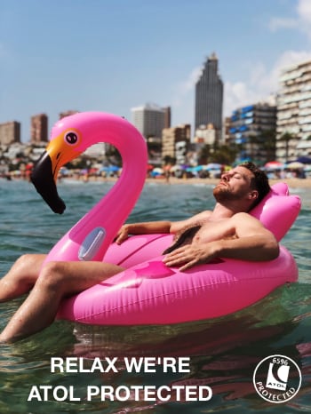 Man relaxing in a blow up Pink Flamingo on the sea with the DesignaVenture ATOL logo